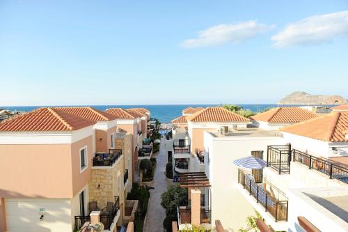 arial view of a town with houses and the ocean at Caldera Bay in Plataniás