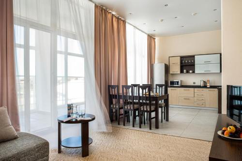 eine Küche und ein Wohnzimmer mit einem Tisch und Stühlen in der Unterkunft Barkhatnye Sezony Yekaterininsky Kvartal Resort in Adler