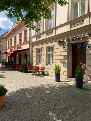 ein Gebäude mit Stühlen und Tischen davor in der Unterkunft Altstadt Hotel in Potsdam