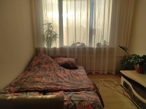 Schlafzimmer mit einem Bett und einem Fenster mit Vorhängen in der Unterkunft NarvaCenter in Narva