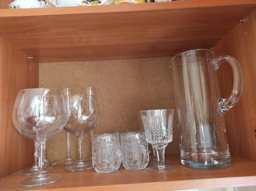 a row of wine glasses and a pitcher on a shelf at NarvaCenter in Narva