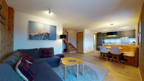 a living room with a couch and a table and a kitchen at Cozy apartment in Veysonnaz, close to the slopes of the 4 Valleys in Veysonnaz