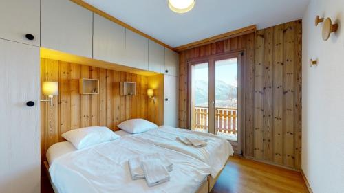 een slaapkamer met een groot wit bed en een balkon bij Cozy apartment in Veysonnaz, close to the slopes of the 4 Valleys in Veysonnaz