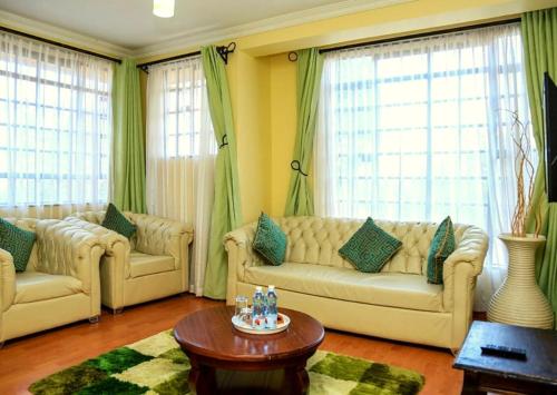 een woonkamer met 2 banken en een tafel bij Davis Court in Nyeri