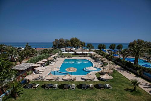uma vista aérea de um resort com uma piscina e guarda-sóis em Gold Apartments em Platanes