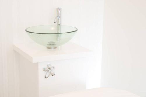 a bathroom sink with a glass bowl on a counter at Airstar Hakata House in Fukuoka