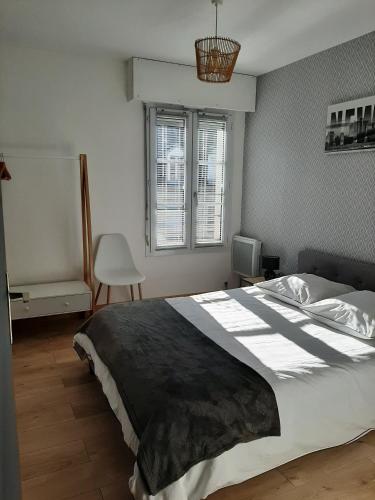 une chambre avec un grand lit et une fenêtre dans l'établissement CHARMANT APPARTEMENT CENTRE VILLE LE RONSARD, à Nogent-le-Rotrou