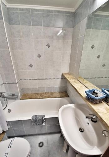 a bathroom with a white tub and a sink at Noufara in Piraeus