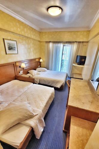 a hotel room with two beds and a television at Noufara in Piraeus