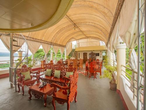 een eetkamer met tafels en stoelen in een gebouw bij OYO 554 Dads Bayview Pension in Puerto Princesa City