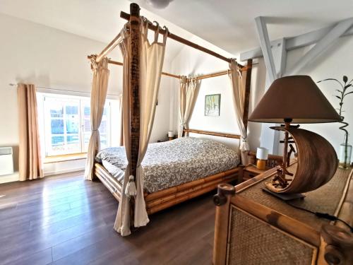 um quarto com uma cama de dossel e um candeeiro em Superbe appartement type loft en duplex rue Buat em Châlons-en-Champagne