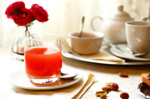 a glass of tea sitting on a table with roses at Locanda dell'Arcangelo in Rocca Massima