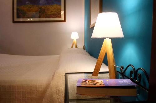 a bedroom with a bed and a table with a lamp at Locanda dell'Arcangelo in Rocca Massima