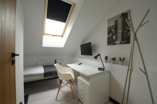 a bedroom with a desk and a bed with a window at Pokoje Gościnne Maestro Aleja Krakowska 84 in Sękocin Stary