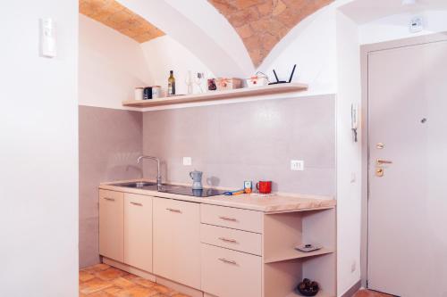 Una cocina con gabinetes blancos y un fregadero. en Restart Accommodations Rosa, en Roma
