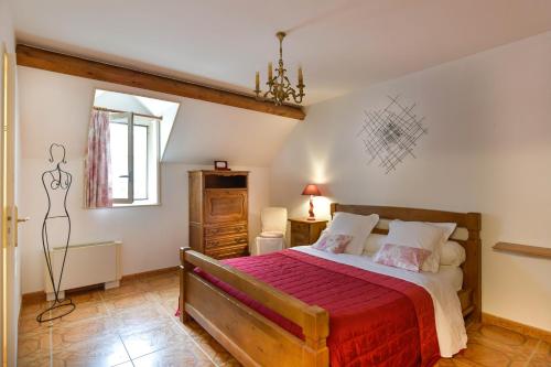 um quarto com uma cama grande e um cobertor vermelho em Gite du Clos Champagnac em Chailly-sur-Armançon
