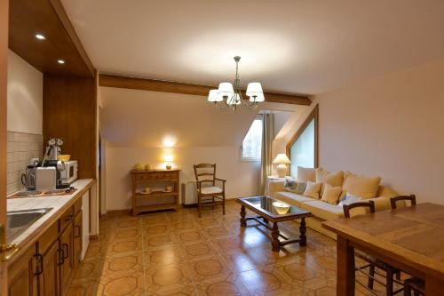 a kitchen and living room with a couch and a table at Gite du Clos Champagnac in Chailly-sur-Armançon