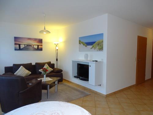 a living room with a couch and a tv at Ferienwohnungen Stranddistel - Apartments von 30 bis 75 qm in Zinnowitz