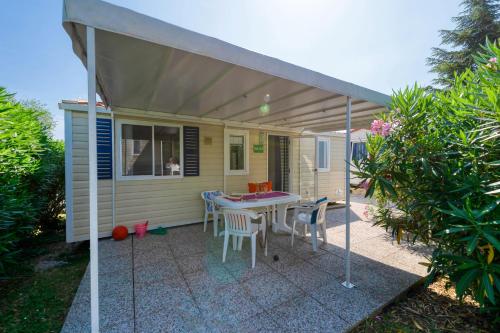 a patio with a table and chairs under an awning at San Benedetto Camping Relais in Peschiera del Garda