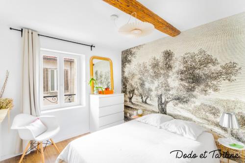 トゥーロンにあるSuperb 1 bedroom in le Mourillon - Dodo et Tartineの白いベッドと壁画が備わるベッドルーム1室が備わります。