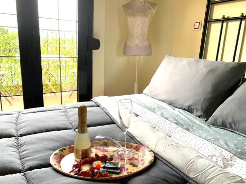 a bottle of champagne and a plate of food on a couch at Atico bellasvistas en el centro Tomelloso Hoster Verona in Tomelloso