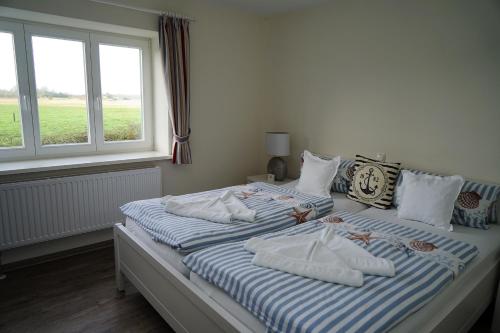 two beds sitting next to a window in a bedroom at Ostseehotel Hunhoi in Niesgrau