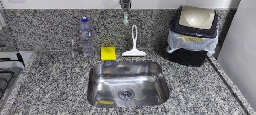 a kitchen counter with a sink and a bottle of water at Aldeia St Sebastien 31 Arembepe in Arembepe