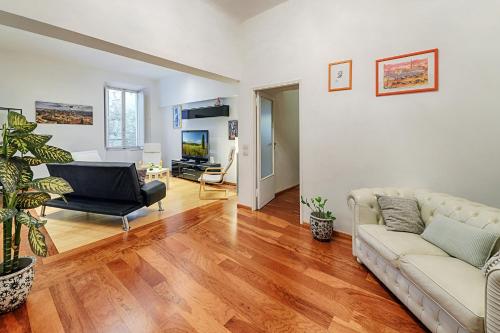 ein Wohnzimmer mit einem Sofa und einem TV in der Unterkunft Ele Home in Siena