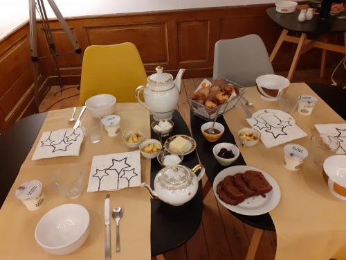 a table topped with plates and bowls of food at La Tour Mandot in Montluel