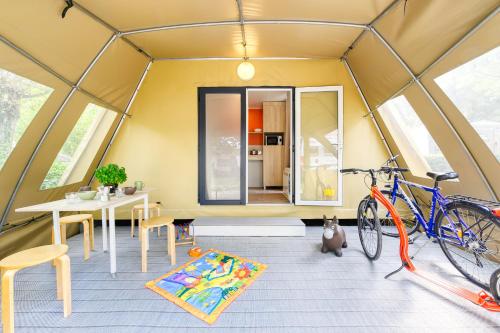 a room with a table and a bike in a tent at San Benedetto Camping Relais in Peschiera del Garda