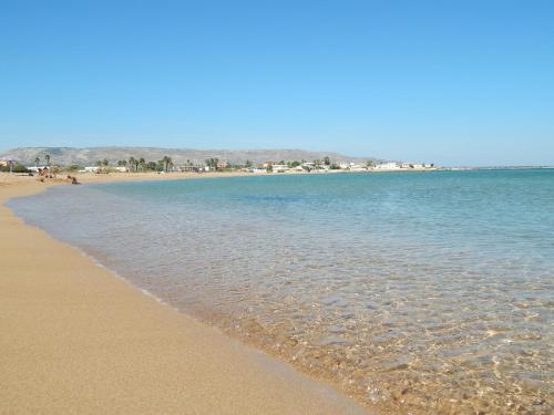 a beach with the ocean and buildings in the background at Beach Front Villas in Calabernardo