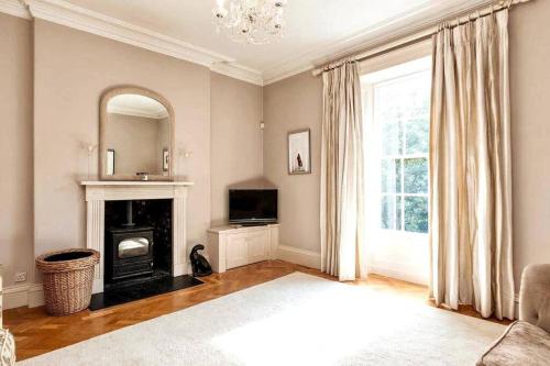 a living room with a fireplace and a mirror at Georgian Villa in Richmond on the River Swale in Richmond