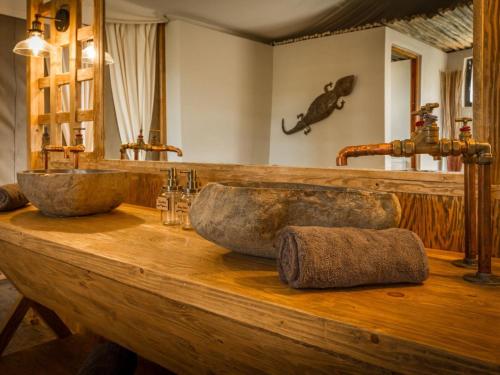 a bathroom with two stone sinks on a wooden counter at Imagine Africa Luxury Tented Camp in Balule Game Reserve