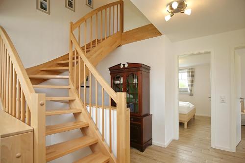 a wooden staircase in a room with a bedroom at Reethaus Sonnenschein in Boltenhagen