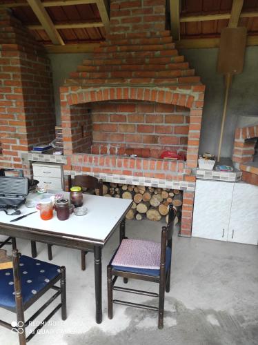 una mesa y sillas frente a una chimenea de ladrillo en Kuca Drinska dolina, en Bajina Bašta