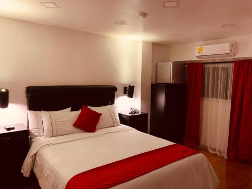 a bedroom with a large bed with a red blanket at Hotel Veler Restaurante in Medellín