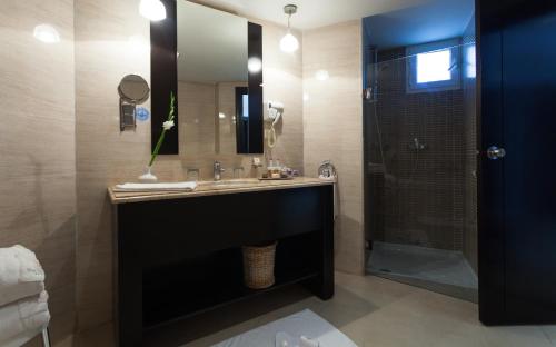 a bathroom with a sink and a shower with a mirror at The Sindbad in Hammamet