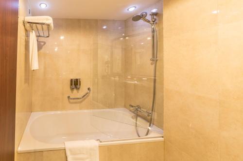 a bathroom with a tub and a shower stall at Ramada Hotel & Suites by Wyndham Bucharest North in Bucharest