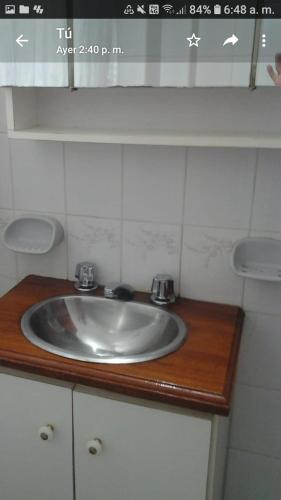 a bathroom sink on a wooden counter top at Los Cuatro Corazones in Villa Gesell