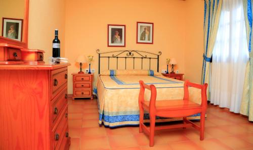um quarto com uma cama, uma cadeira e uma cómoda em Vip Villas - Caleta Dorada em Caleta de Fuste