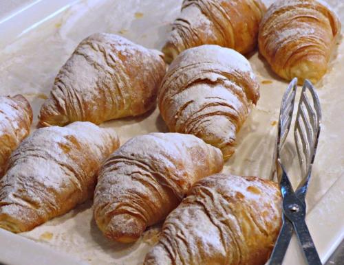 ein Tablett voller Croissants mit einer Schere in der Unterkunft BG Rei del Mediterrani in Playa de Muro