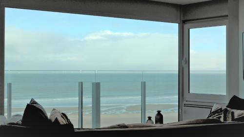 a room with a view of the ocean through a window at NEPTUNE Wenduine met zeezicht - VOSPROPERTIES in Wenduine