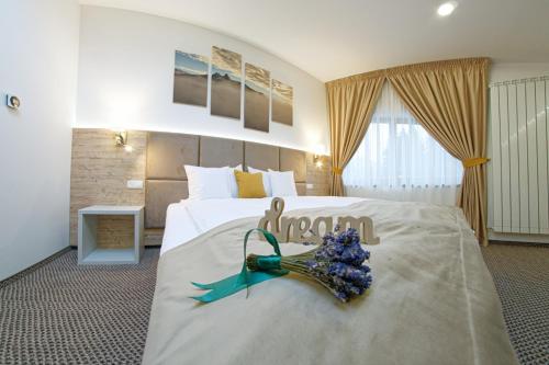 um quarto de hotel com uma cama com um arranjo de flores em AQUARIUS BOUTIQUE HOTEL em Câmpulung Moldovenesc