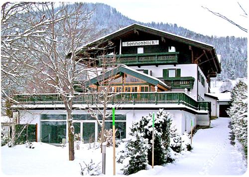 a large building in the snow in front at Landhaus Sonnenblick in Reit im Winkl
