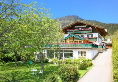 a large house with a balcony on a hill at Landhaus Sonnenblick in Reit im Winkl