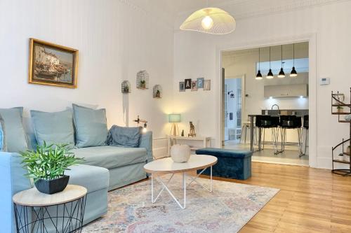 un salon avec un canapé bleu et une table dans l'établissement #J0 The sweet Jaurès, à Grenoble