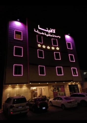 a hotel with purple lights on top of it at لافينا حائل للاجنحة الفندقية in Hail