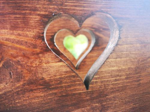 a heart on top of a wooden table at Őrség Kincse Kis Apartman - 4 főre in Hegyhátszentjakab