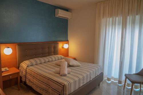 a bedroom with a bed with two pillows on it at Hotel Paradiso in Grottammare
