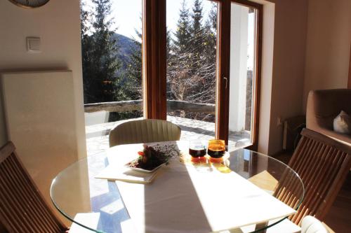 a glass table with two glasses on it in front of a window at 4Badgers / 4Jazavca - Mountain House in Kopaonik